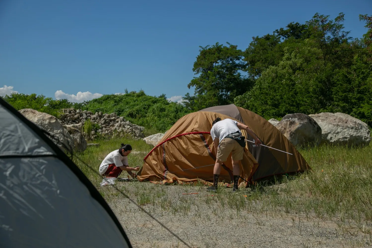 石切場近くの建設資材置き場でテントを張る石井友人と福永大介