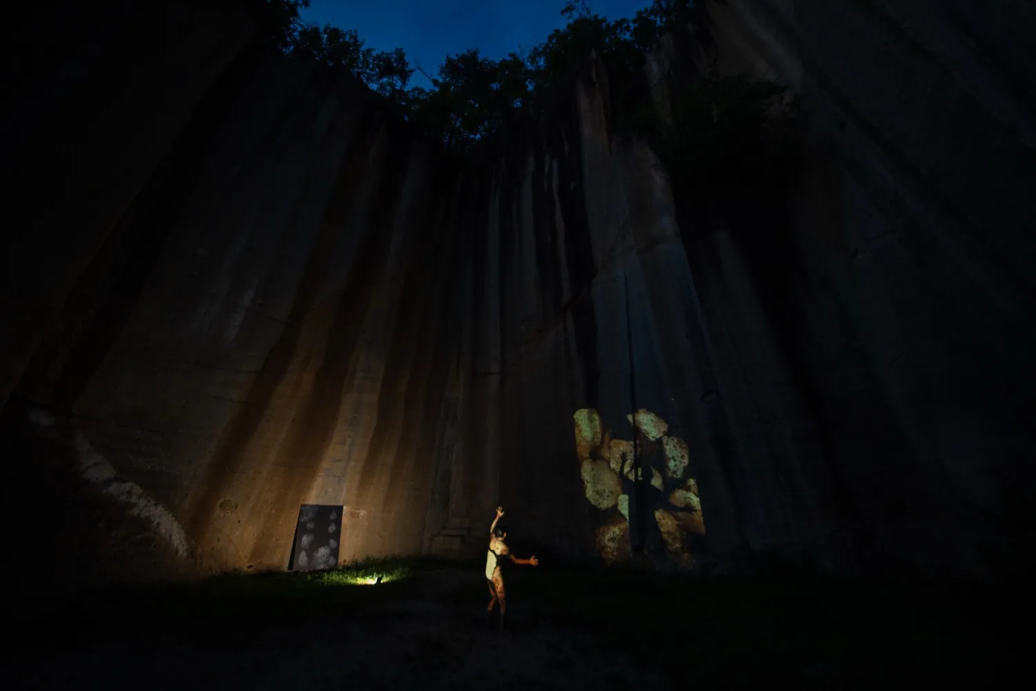 岩壁に投影された映像を前にしてパフォーマンスを行う石井友人