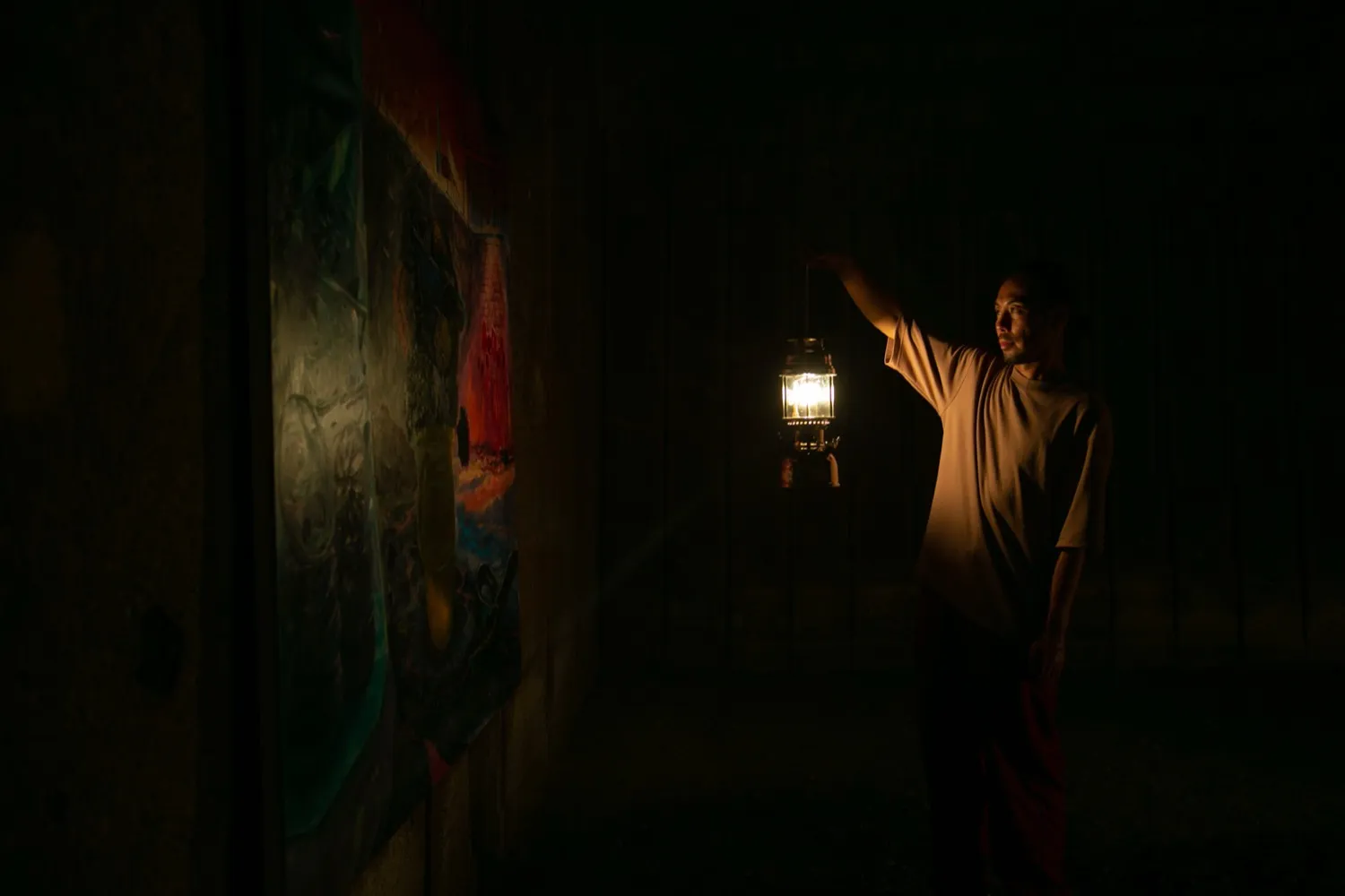 ランタンで絵画を照らす福永大介