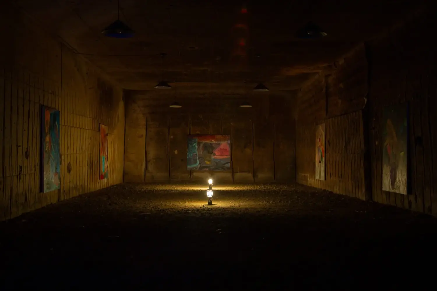 洞窟内でランタンに照らされた福永大介の絵画